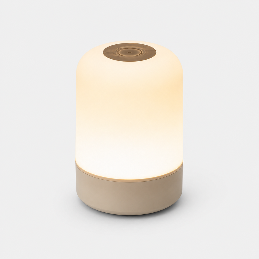 Lampe cylindrique allumée en lumière chaude, diffuseur blanc et base beige, fond neutre.