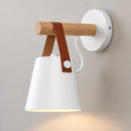 Détail de l’applique murale blanche avec bras en bois et sangle brune