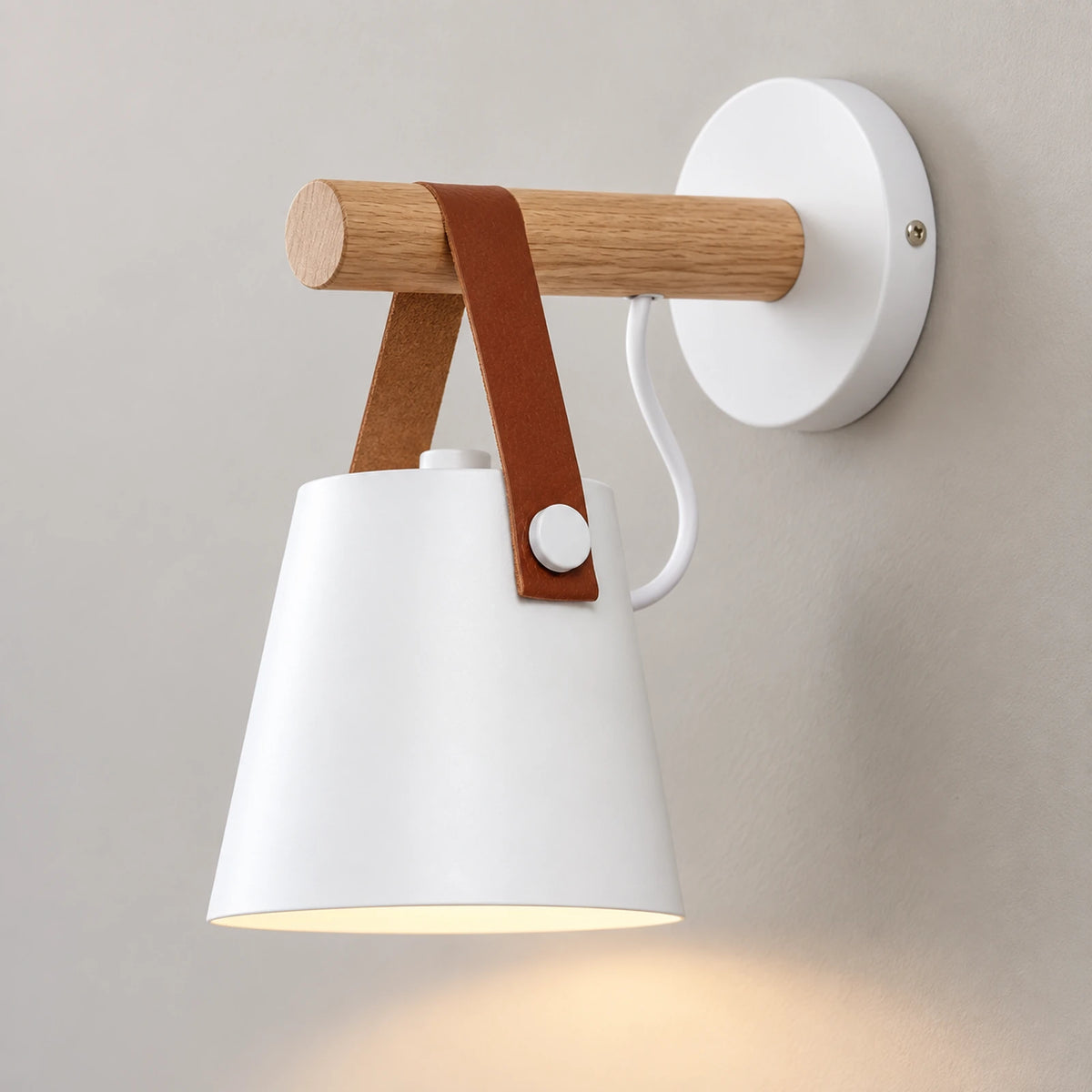Détail de l’applique murale blanche avec bras en bois et sangle brune