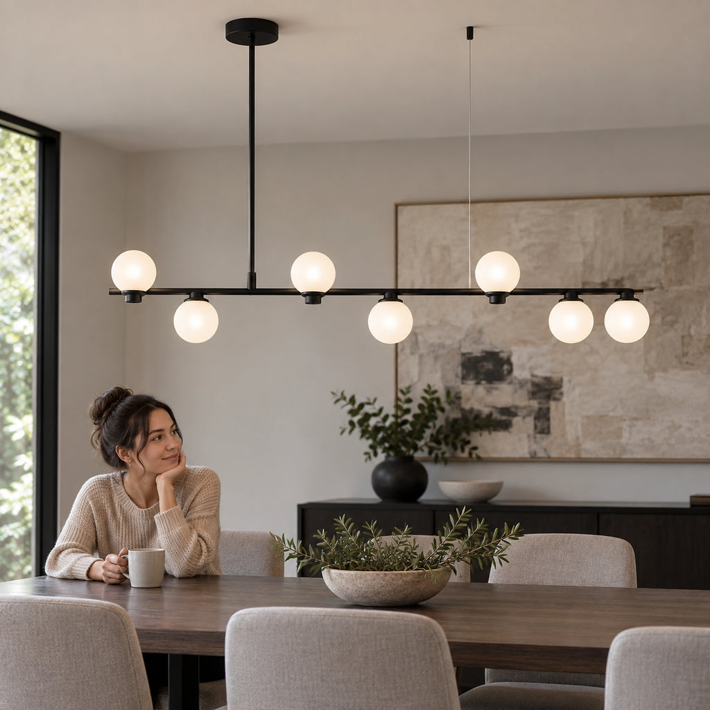Suspension linéaire noire à 7 globes opalins dans une salle à manger