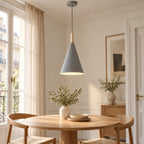 Suspension grise conique installée au-dessus d’une table