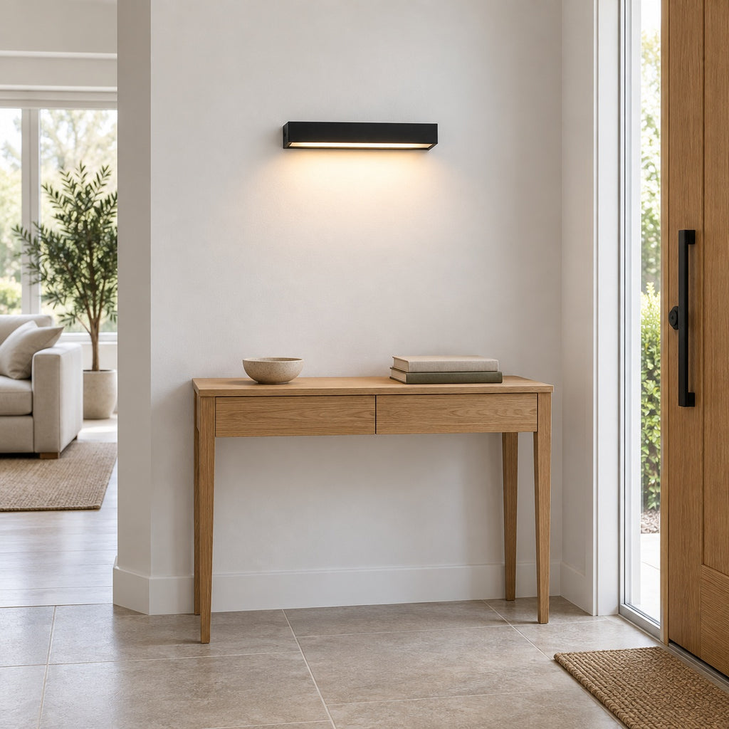 Applique noire de 30 cm installée au-dessus d’une console dans une entrée