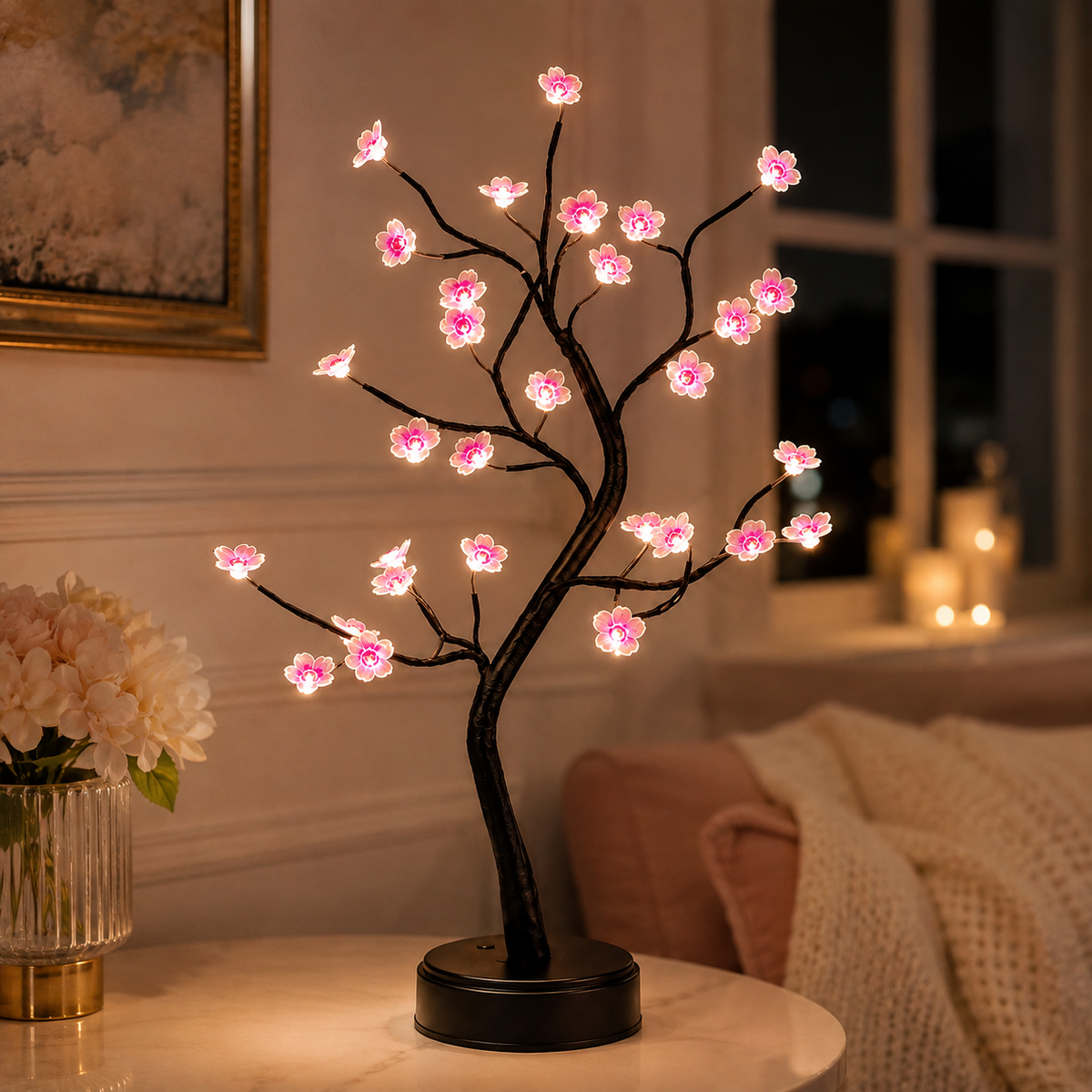 Lampe arbre fleur de cerisier allumée dans une chambre à côté d’un lit