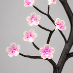 Détail des fleurs de cerisier roses et blanches et des LED sur les branches