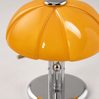 Détail du pied et de la base ronde en métal chromé de la lampe champignon orange