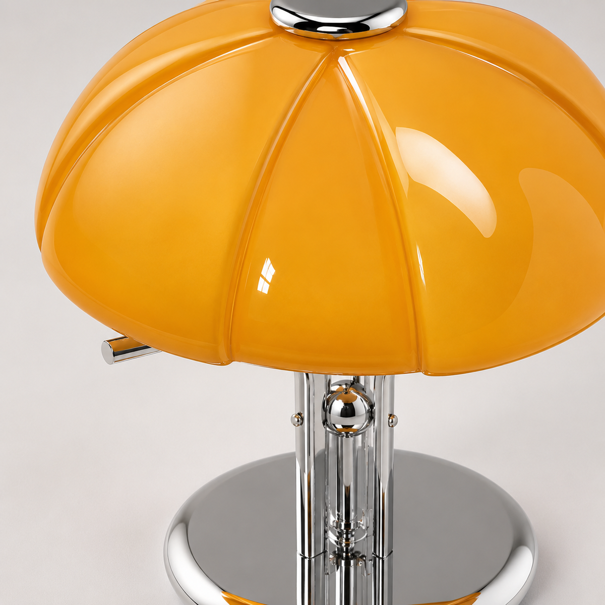 Détail du pied et de la base ronde en métal chromé de la lampe champignon orange