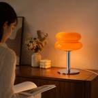 Lampe en verre orange allumée sur une table dans un intérieur