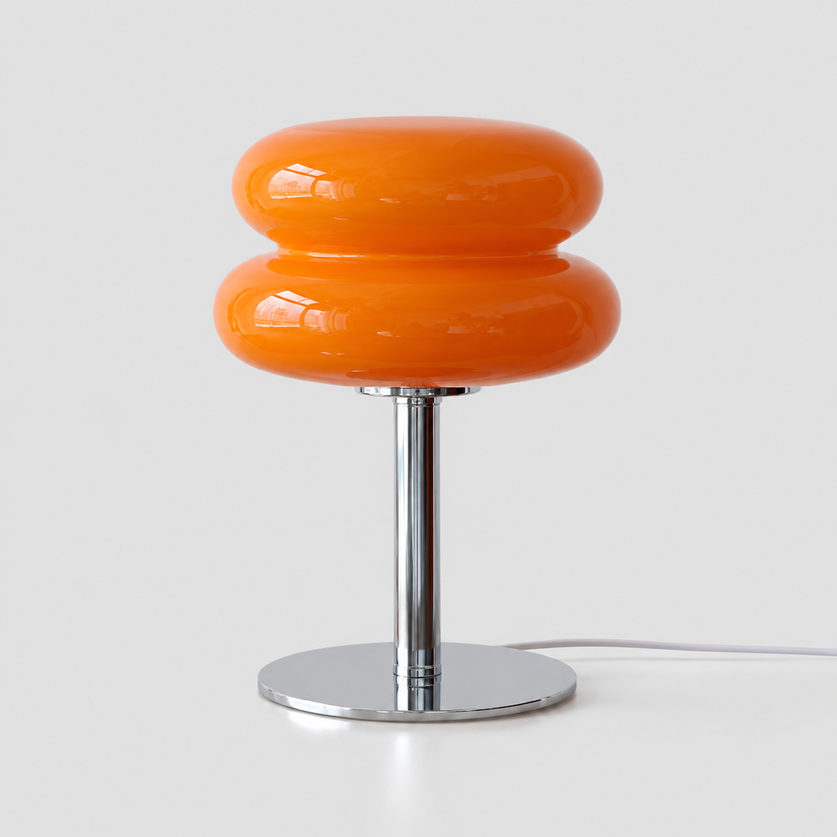 Lampe en verre orange à abat-jour arrondi à deux niveaux et pied chromé, vue de face