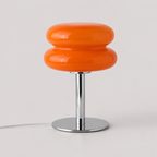 Lampe en verre orange à pied chromé vue de trois quarts