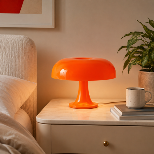 Lampe champignon orange allumée sur une table de chevet blanche dans une chambre