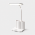Lampe LED blanche à bras flexible avec porte-stylos et support téléphone, sur fond gris.