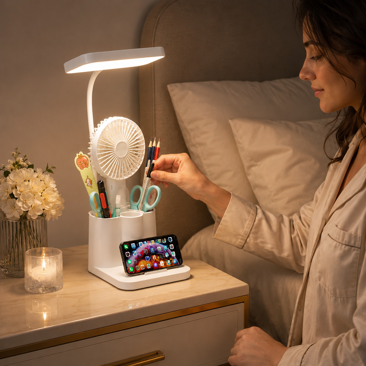Personne ajustant le bras flexible de la lampe allumée posée sur une table de chevet.