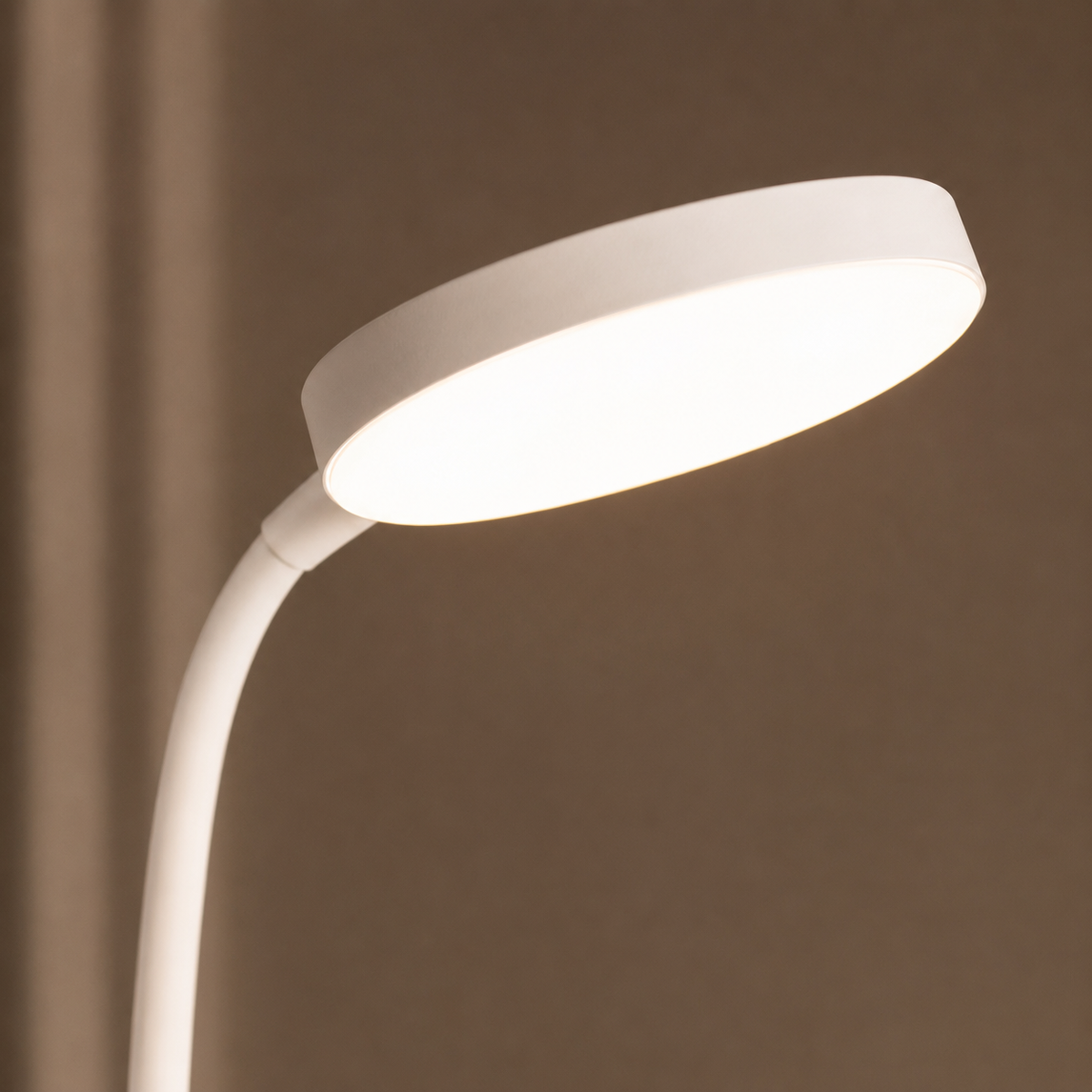 Gros plan de la tête lumineuse circulaire allumée et du col flexible orientable.