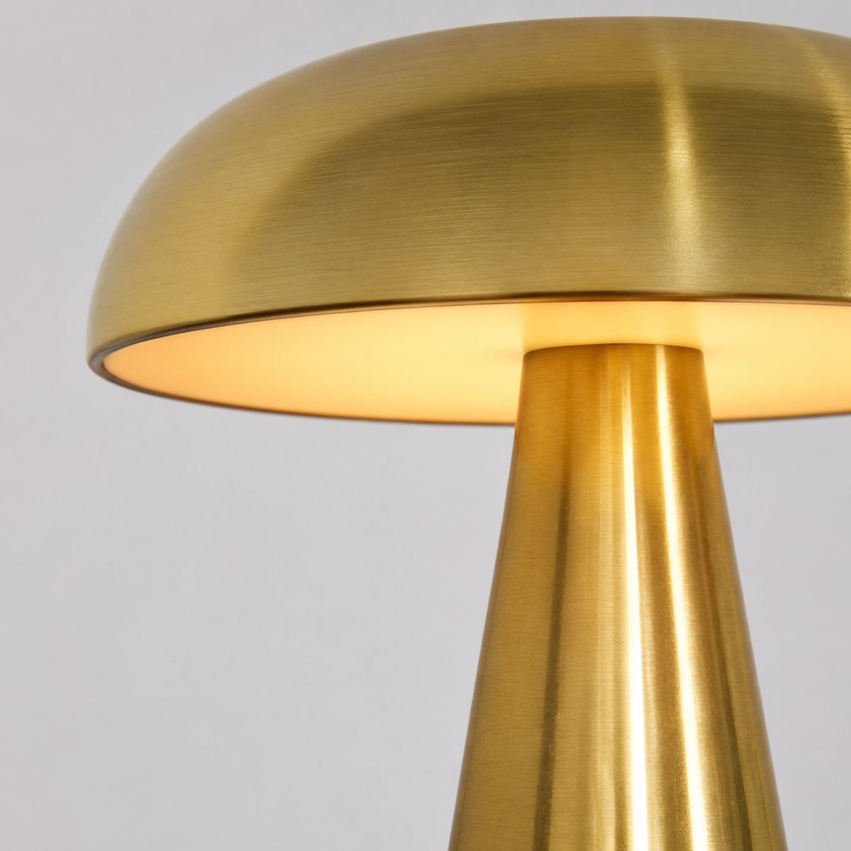 Détail de l’abat-jour doré et du pied évasé de la lampe champignon