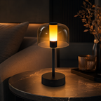 Lampe de chevet tactile noire allumée en lumière chaude sur une table ronde