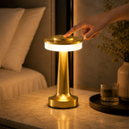 Main effleurant le dessus de la lampe dorée allumée pour régler l'éclairage.