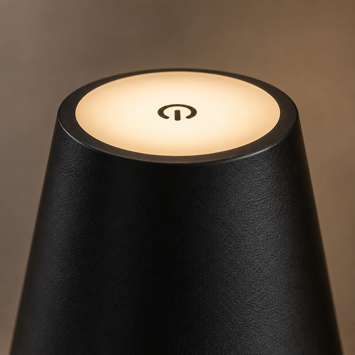 Gros plan de l'abat-jour noir allumé en lumière chaude, bouton tactile visible au sommet.
