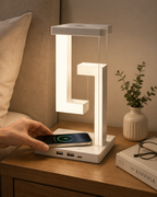 Téléphone posé sur le chargeur à induction intégré au socle de la lampe suspendue