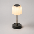 Lampe éteinte vue de face, abat-jour plissé et tige télescopique en position haute.