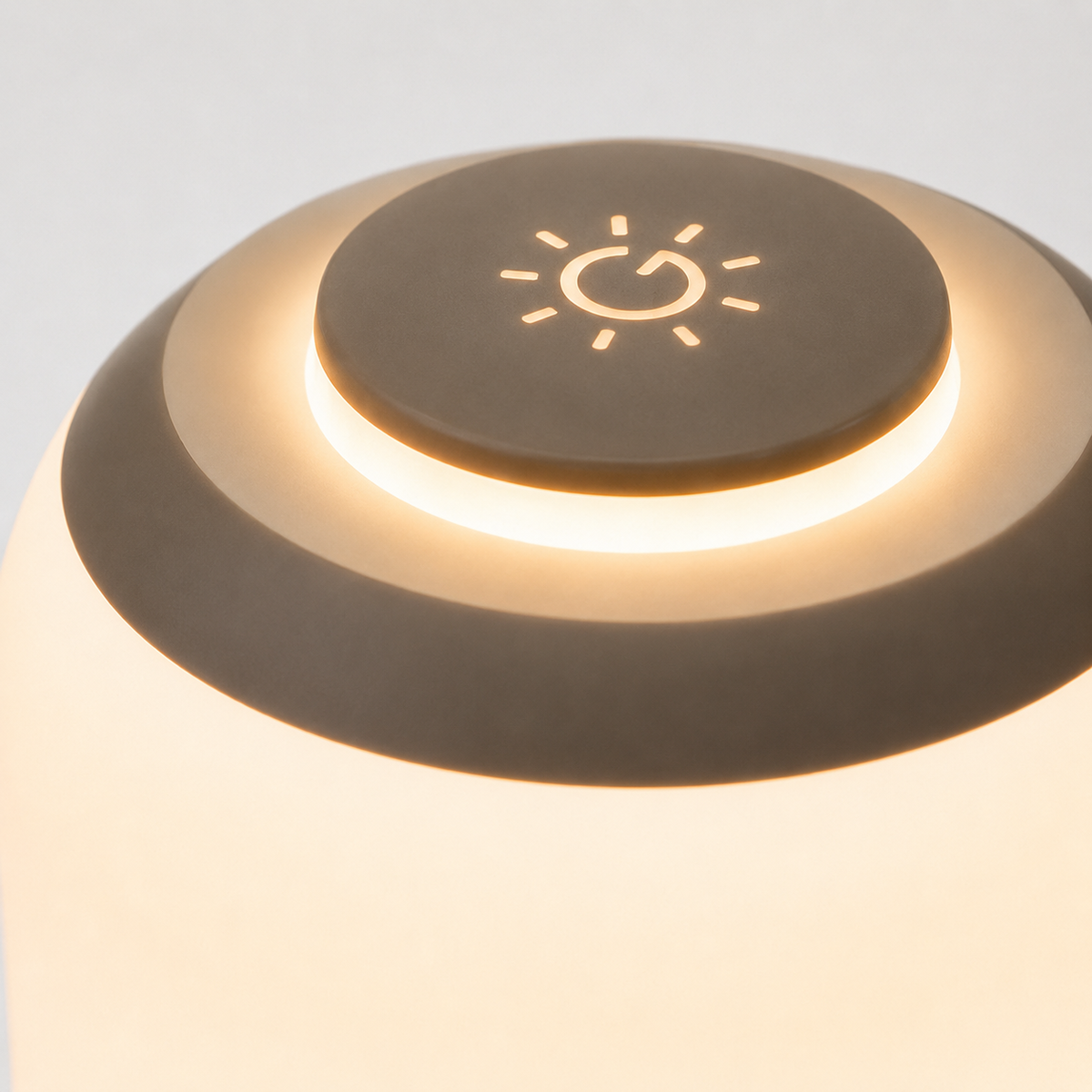 Vue du dessus de la lampe montrant la commande tactile gravée d'un motif soleil.